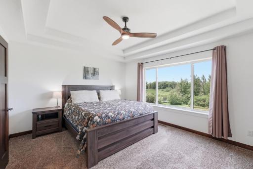 Primary bedroom boasts beautifully designed tray ceilings, framing in a spacious place to unwind.