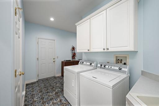 Spacious laundry room with utiliity sink and storage