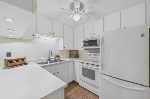 Bright kitchen with under-cabinet lights, new dishwasher, and garbage disposal.