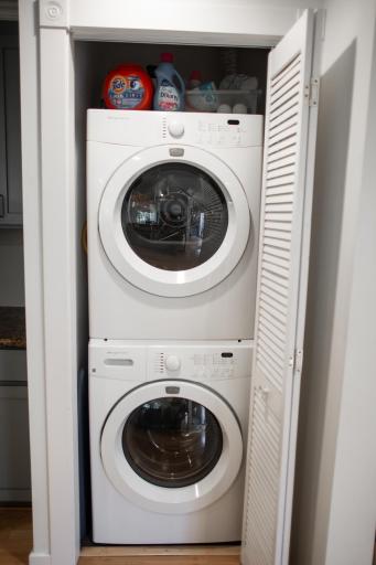Stackable washer and dryer are tucked away neatly.