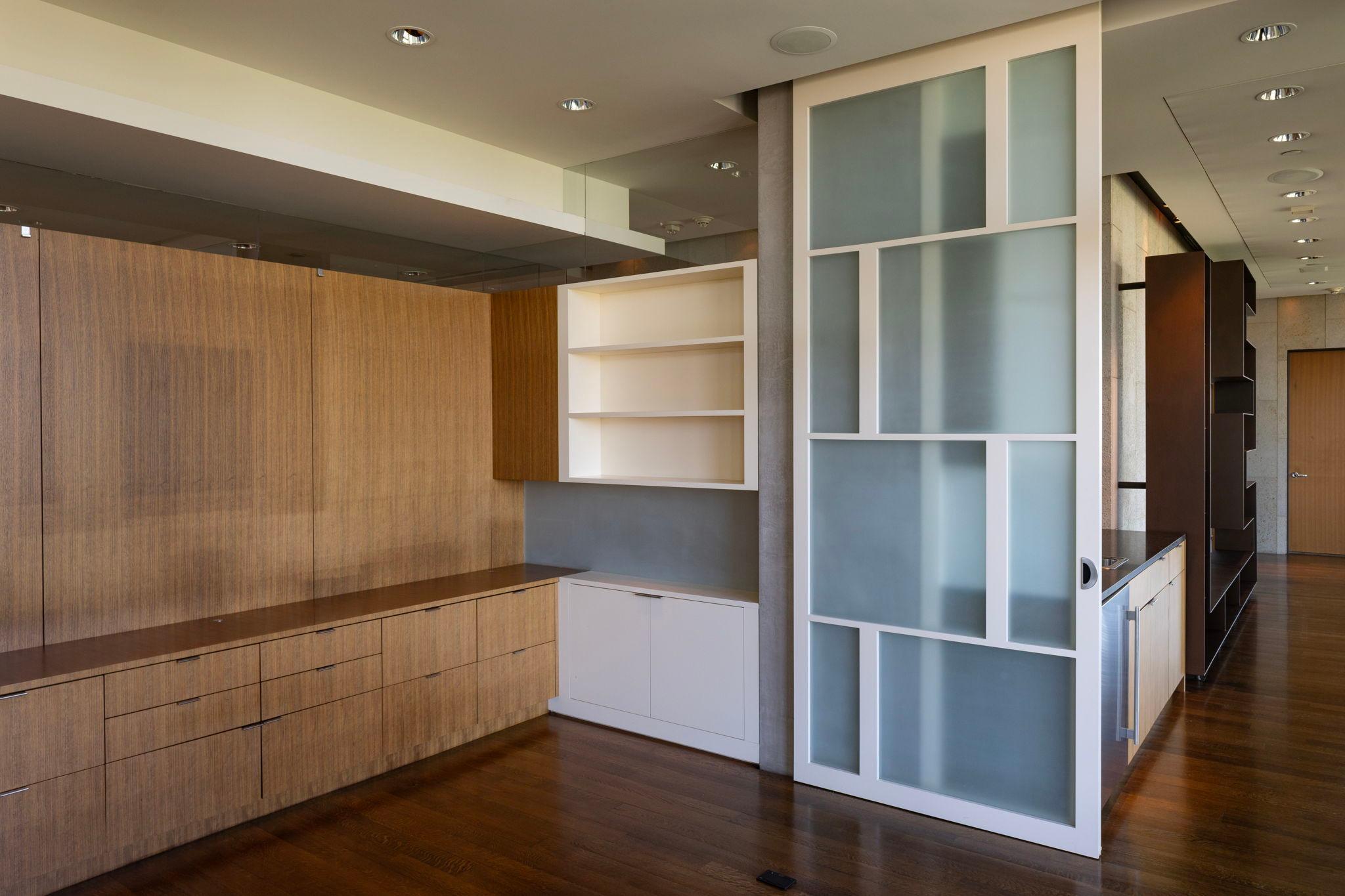 Office with extensive built-ins lies between family room & primary suite
