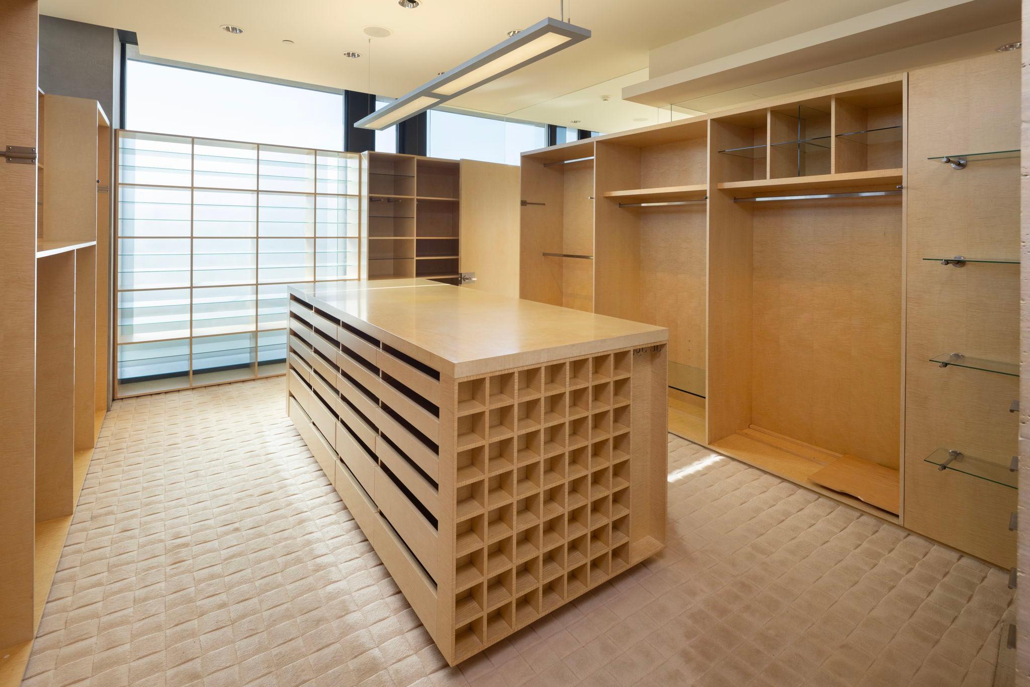 Highly customized center island primary bedroom closet