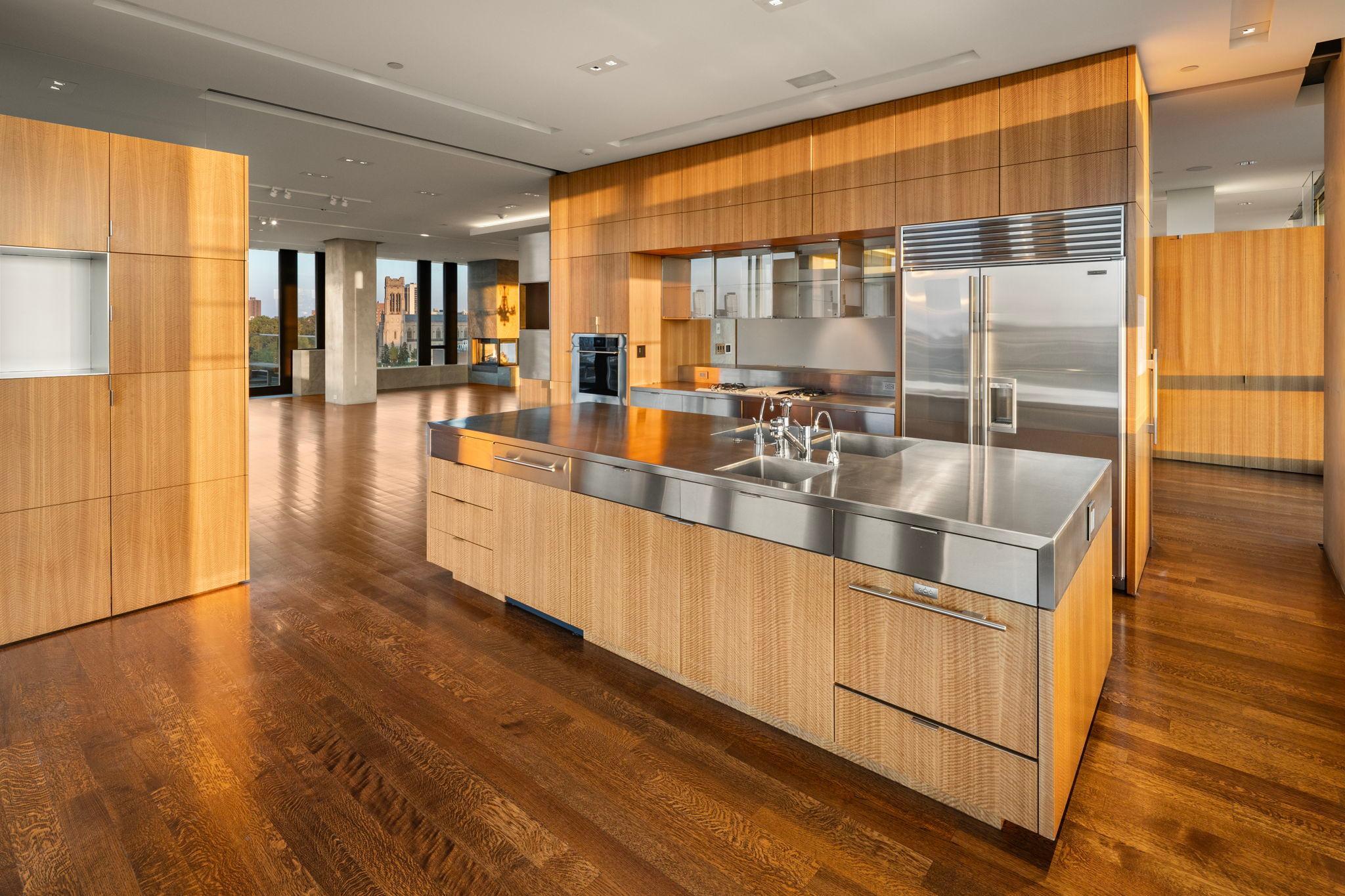 Custom designed center island kitchen with stainless steel counters and almost endless cabinetry