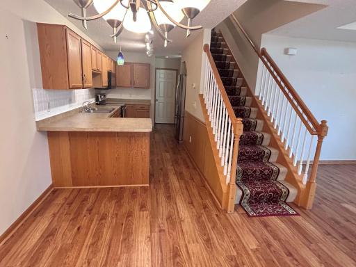 View from dining area looking into the kitchen and stairway leading to upper level.