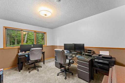 The second bedroom, currently used as an office, with a large window to the yard