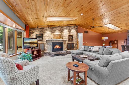 Spacious open living room with a cozy gas fireplace and large front windows offering great natural light and amazing views