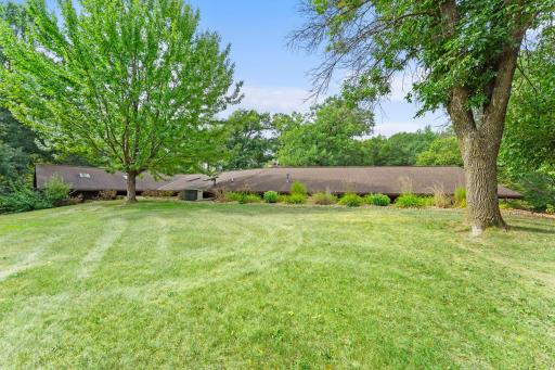 A view from the backyard shows off the tasteful landscaping and towering trees