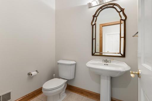 Convenient main-level half bath featuring a classic pedestal sink and a clean, neutral design.