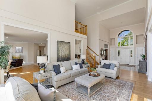 Another view of the impressive two-story great room, highlighting the open layout, soaring ceilings, and seamless flow to the surrounding main-level living spaces.