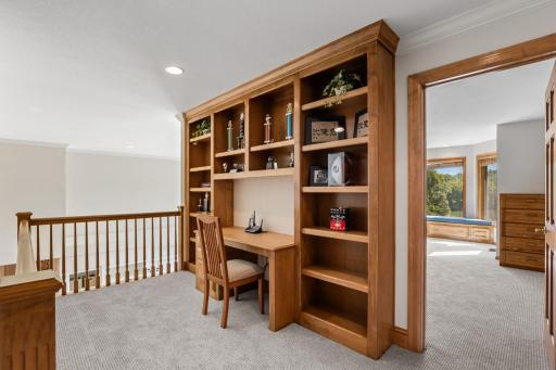 Upper-level loft area features a built-in desk and shelving, creating a convenient space for homework, studying, or a home office.