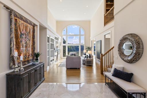 Grand two-story foyer opens to the light-filled great room, where soaring ceilings, dramatic windows, and beautiful Turtle Pond views create an impressive first impression.