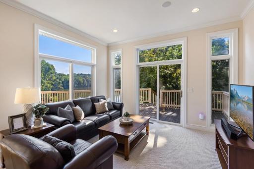 Inviting main-level sitting room just off the kitchen, featuring an abundance of natural light, picturesque Turtle Pond views, and easy access to the spacious deck.
