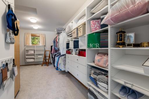 Impressive walk-in primary closet offering exceptional storage with extensive custom shelving, built-in drawers, and plenty of room to keep everything beautifully organized.