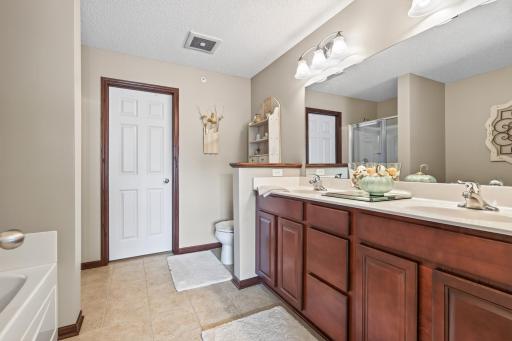 Spacious Primary private bathroom with tiled floors, double sinks, large soaking tub & separate shower.