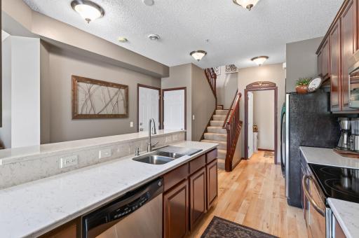 Updated kitchen with Quartz countertops, timeless tiled backsplash, ample raised panel cabinets (46" uppers!), with crown-molding and Stainless Steel Appliances - Don't miss the nice pantry too!