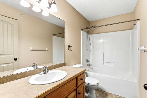 Additional upper-level full bathroom featuring a spacious vanity, large mirror, and tub/shower combination.