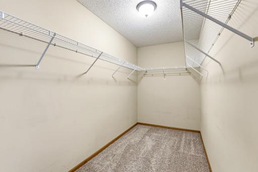 Large primary walk-in closet with generous shelving and hanging space for organized storage.