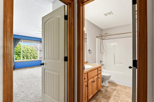 Additional upper-level full bathroom featuring a tub/shower combination, spacious vanity, and convenient access from the hallway.