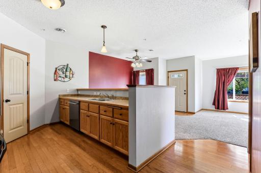 Open kitchen layout with hardwood floors, ample cabinetry and counter space, pantry, breakfast bar, and seamless connection to the dining and living areas.
