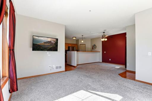 Open-concept living and dining area with abundant natural light and easy flow to the kitchen. TV wall mount will remain with the home; TV is not included.