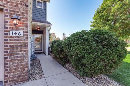 Welcoming covered entryway with a concrete walkway leading to the front door.