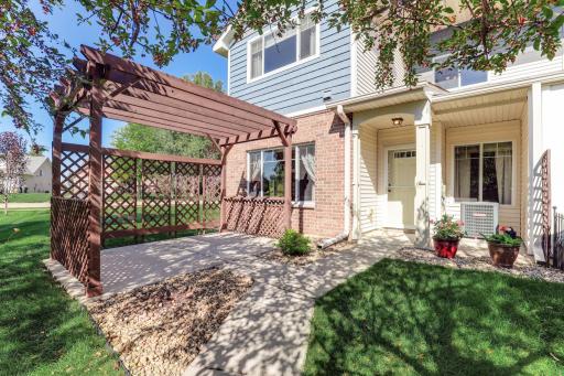 Private patio with pergola and added side panels for enhanced privacy—an outdoor feature that sets this unit apart from others in the community.