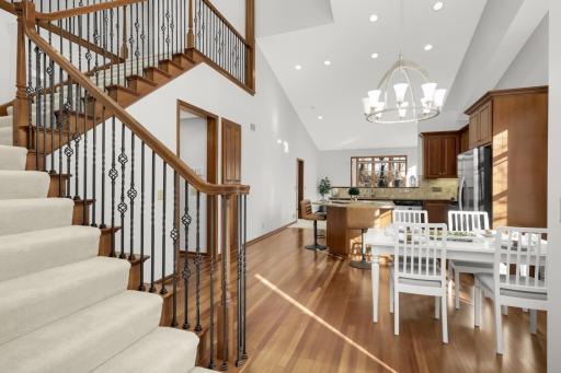Grand open-concept main level with soaring ceilings, hardwood floors, and elegant staircase detail.