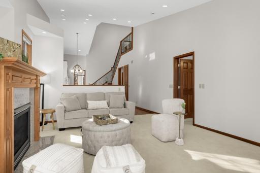 Bright main-level living room featuring a gas fireplace, large windows, and open flow ideal for lakeside entertaining.
