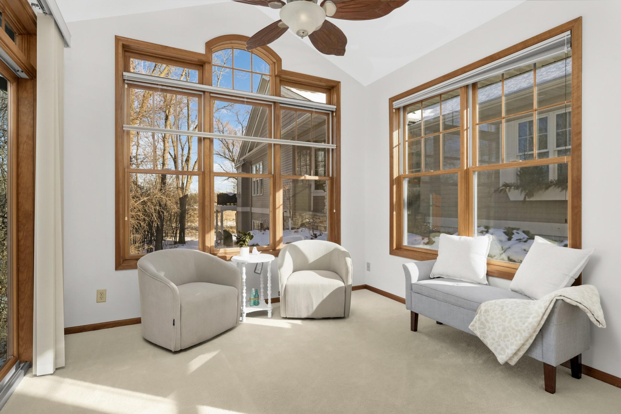 Sun-filled sitting room with expansive windows and peaceful views—perfect for morning coffee overlooking Eagle Lake.