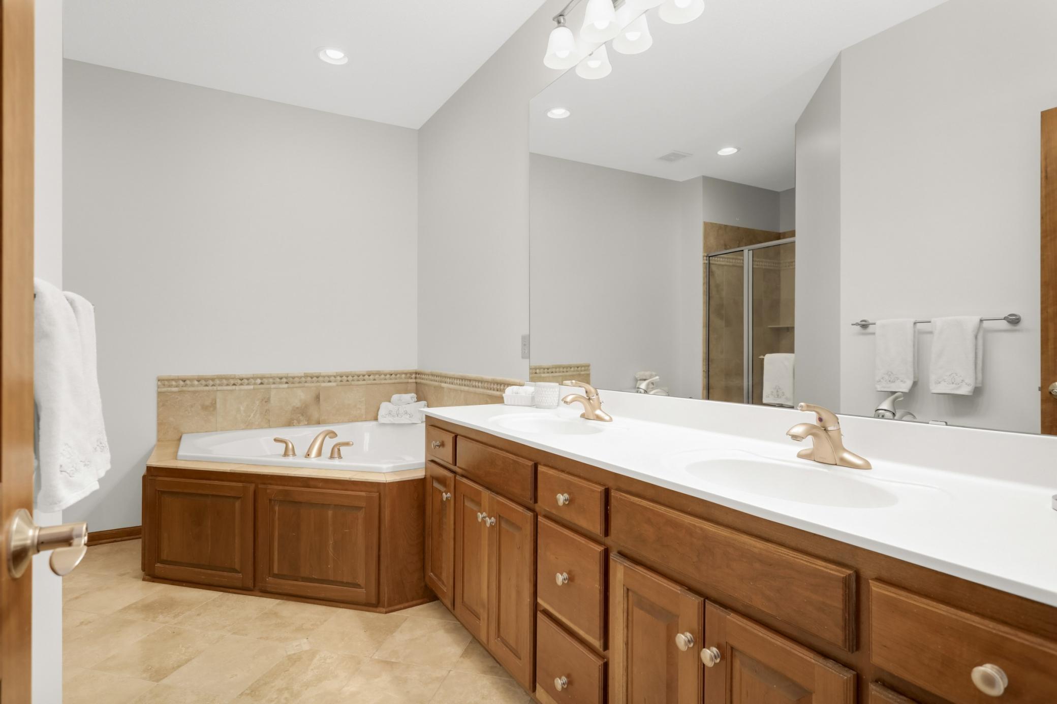 Large main level primary bath with dual vanity, spa-style soaking tub, and separate shower.