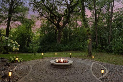Paver patio and fire pit surrounded by mature trees