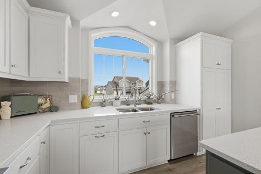 This beautifully designed kitchen features quartz countertops, custom cabinetry, and an expansive center island offering plenty of prep and gathering space. Professional Frigidaire appliances complete the space.