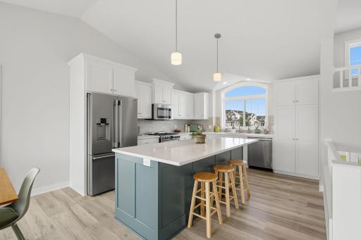 The oversized center island provides an abundance of workspace while creating a natural gathering spot in the heart of the home. It is perfectly positioned to keep the kitchen connected to the main living areas.