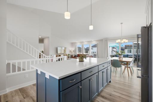 The impressive vaulted great room is the heart of the home, seamlessly connecting the living, dining, and kitchen spaces. Oversized windows bring in abundant natural light.