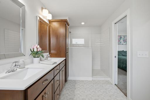 Unwind in the separate soaking tub in your private primary bathroom. Double sinks with convenient tip-out trays provide additional functionality and storage.