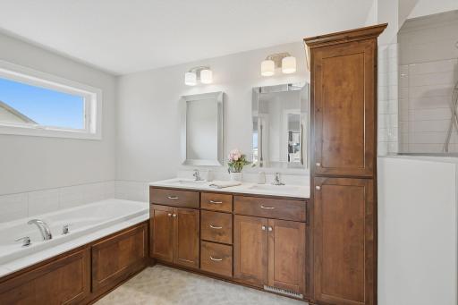 The private primary bathroom was designed for both function and relaxation, featuring a walk-in shower, soaking tub, and double sinks.