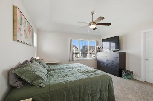 The primary suite offers plenty of room for a complete bedroom setup while maintaining an open, peaceful feel. Natural light and vaulted ceilings enhance the space.