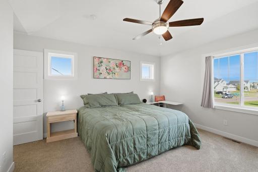 The private primary suite is tucked away on its own level, creating a true owner's retreat. Vaulted ceilings make the already spacious bedroom feel even larger.