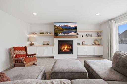 A cozy gas fireplace anchors this spacious lower-level living area. Custom built-ins provide both style and useful storage.