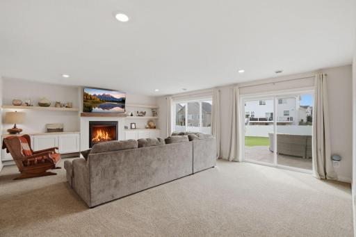 The finished walkout lower level adds another spacious gathering area to the home. The recreation room features custom built-ins, a gas fireplace, and direct access to the backyard patio.