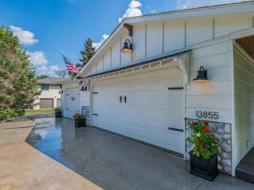 3 car attached garage, concrete driveway, and polished landscape edging.