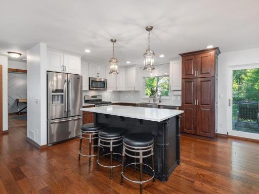 Hickory cabinetry with quartz countertops and subway tile.