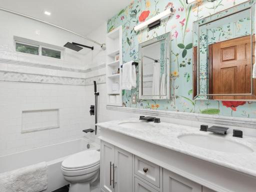 Main level full bath with timeless white finishes, tile and fixtures.