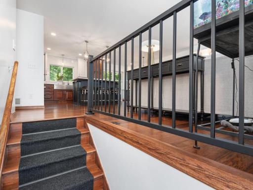 Entry with rod iron railings and hickory wood floors.
