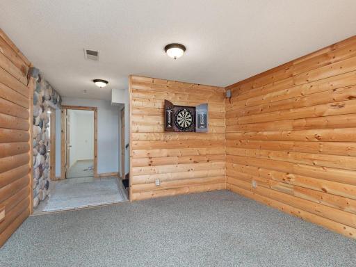 Rustic log panel walls downstairs. Pictured is the lower level family area.