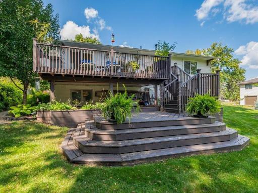 Back of home with deck and gathering areas.