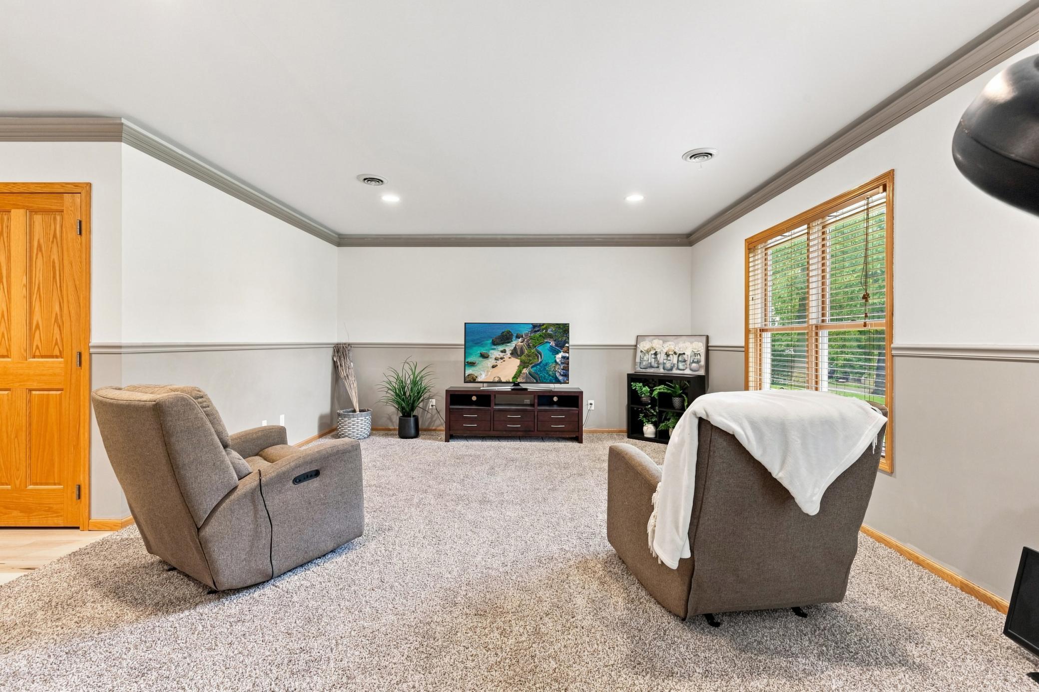 Family Room in lower level, with walkout to back yard and Bedroom in lower level- with ample unfinished storage space