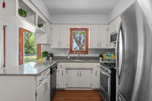 The updated kitchen features stainless steel appliances, Cambria countertops (2019), and luxury vinyl plank flooring that extends into the dining area.