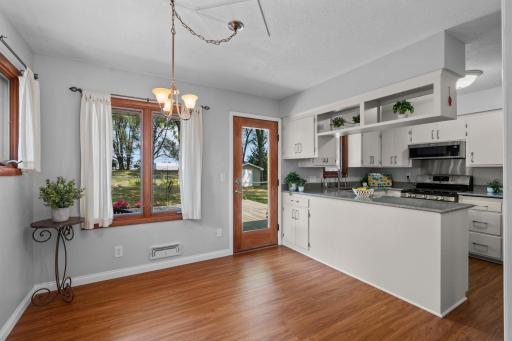 The kitchen flows seamlessly into the dining room, highlighted by a classic hanging light fixture and direct access to the spacious deck.