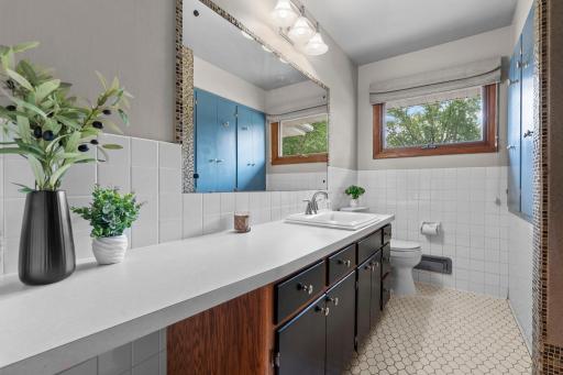 A shared full bathroom includes tile flooring, a spacious single-sink vanity with abundant storage, and a tub/shower combination.